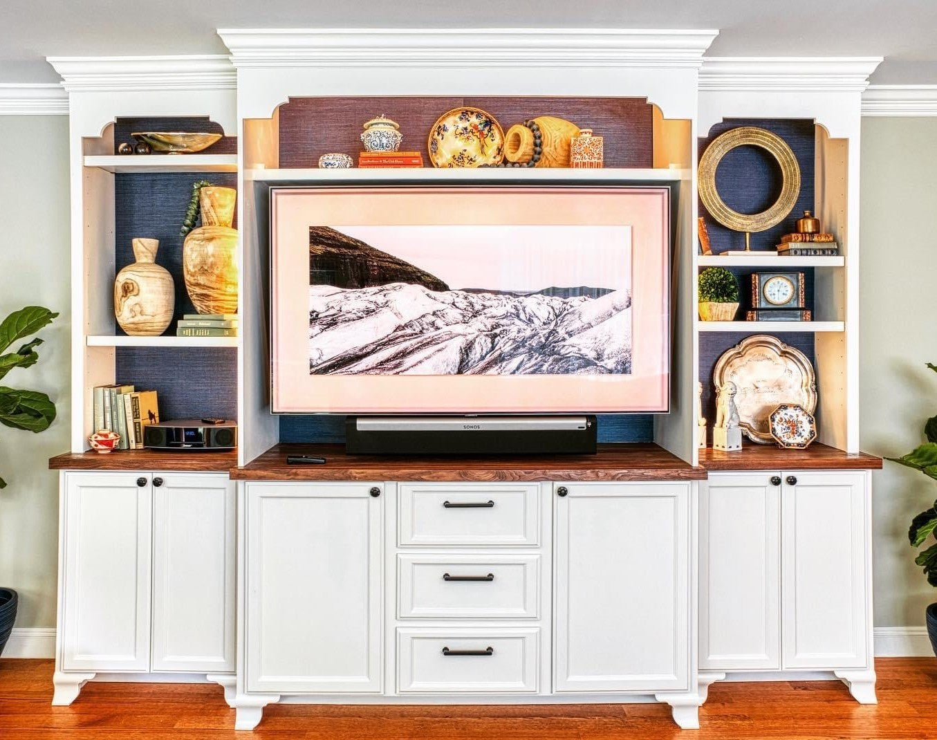 White TV wall unit built in birch with fancy feet, crown molding, stained walnut base cabinet top, doors and drawers.