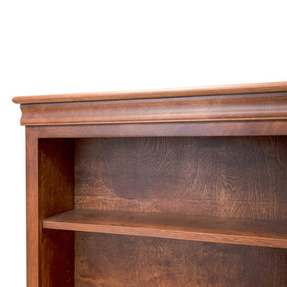 Acadia Madison Bookcase featuring birch crown moulding. Shown at a close up angle to highlight the crown moulding in Walnut finish.