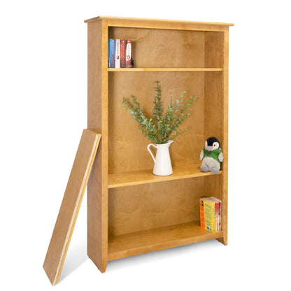 Acadia Shaker Bookcase built with birch featuring adjustable shelves pictured with items on it to highlight storage space. Shown in Autumn Gold finish.